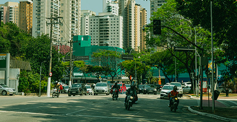 imagem de rua movimentada com motos e carros