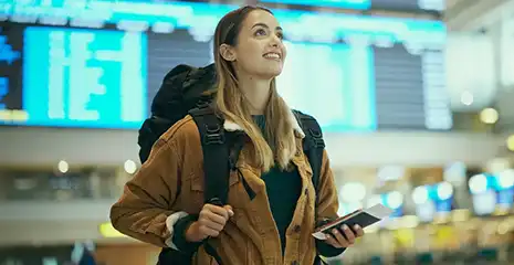 Mulher de mala com celular na mão