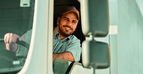 homem sorrindo dirigindo caminhão