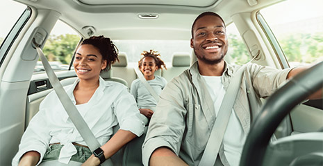 Família usando cinto de segurança dentro do carro