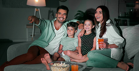 familia reunida no sofá enquanto assiste filme