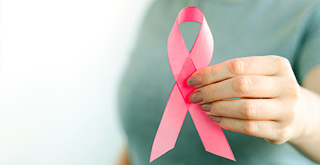 Mulher segurando laço rosa