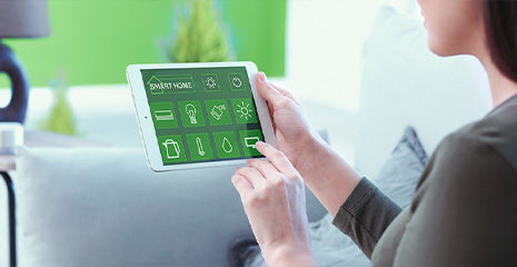 Mulher controlando funcionalidades de sua casa pelo tablet