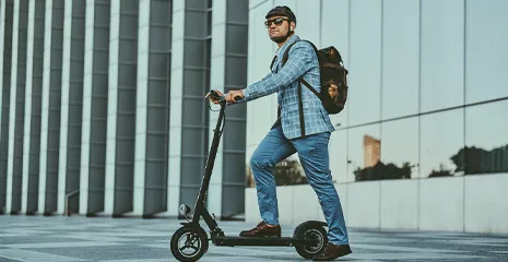 Homem de capacete apoiado em um patinete